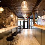 Modern interior of a restaurant with wooden floors and exposed beams.