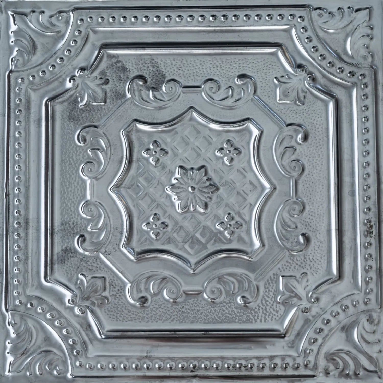 Decorative metallic ceiling tile with intricate patterns.