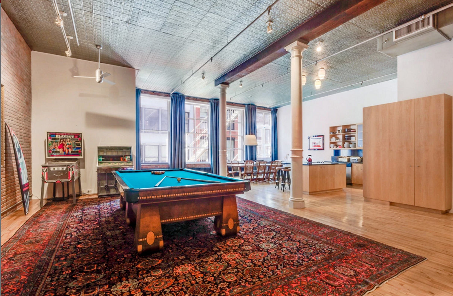 Modern apartment interior with a pool table on a decorative rug.