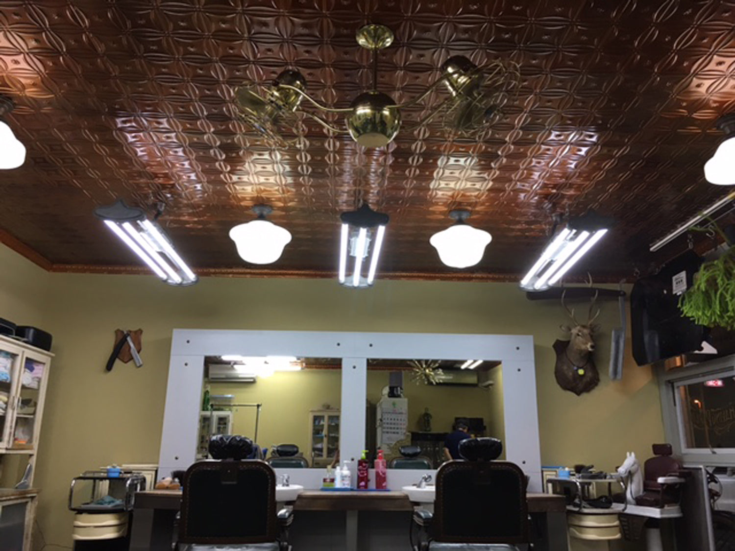 Salon interior with mirrors, chairs, and decorative ceiling.