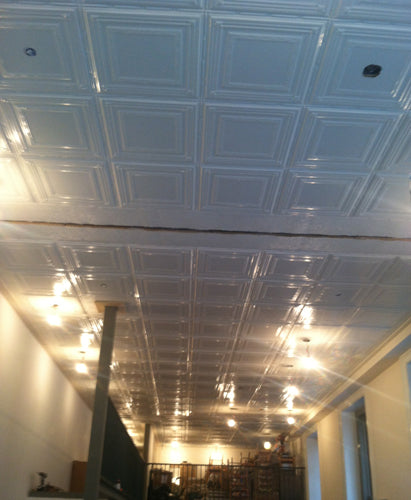 Ceiling with square tiles and visible light fixtures