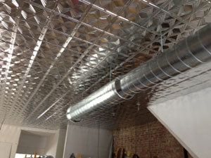 Metallic ductwork against a textured ceiling