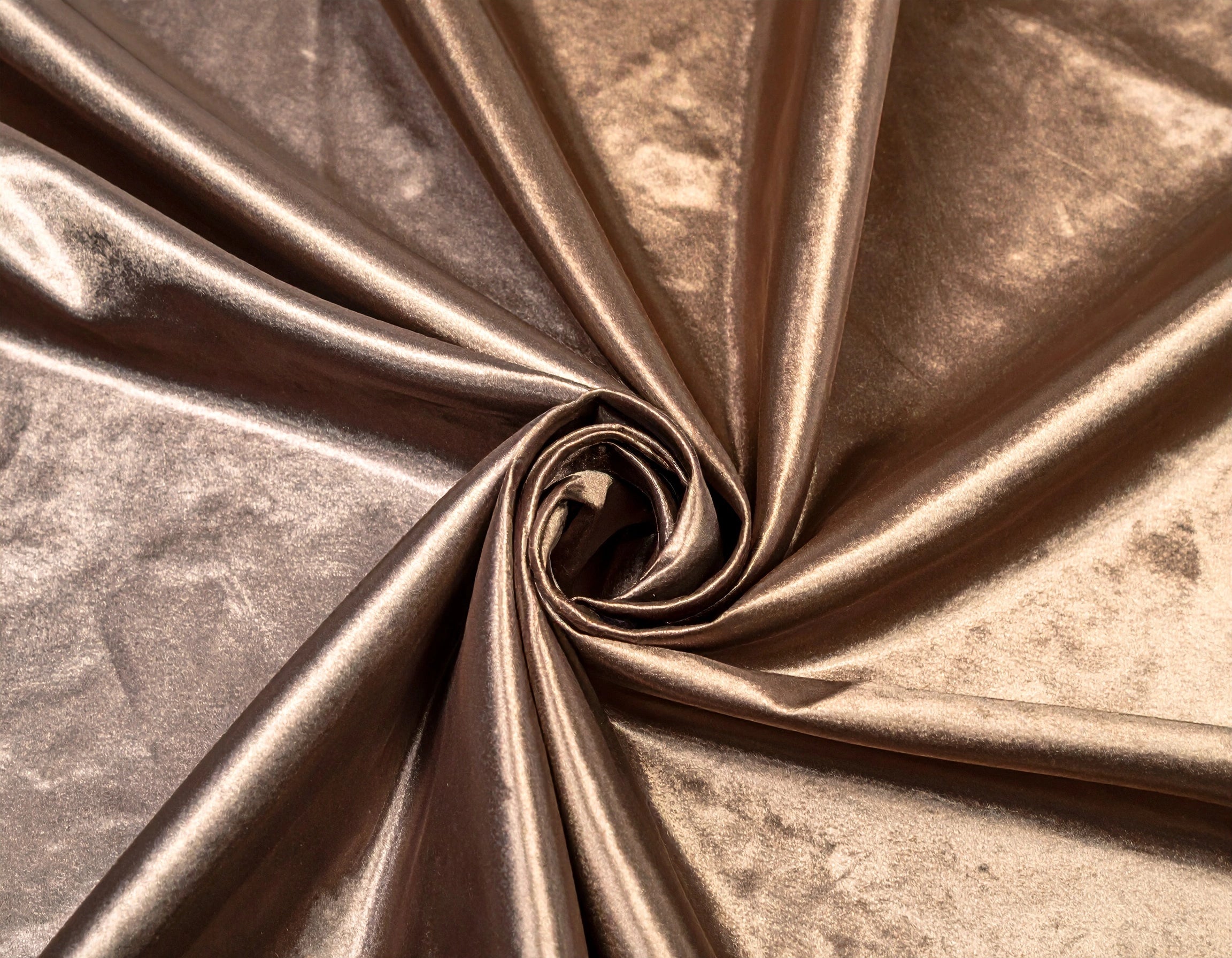 Close-up of bronze metallic fabric with a swirl pattern