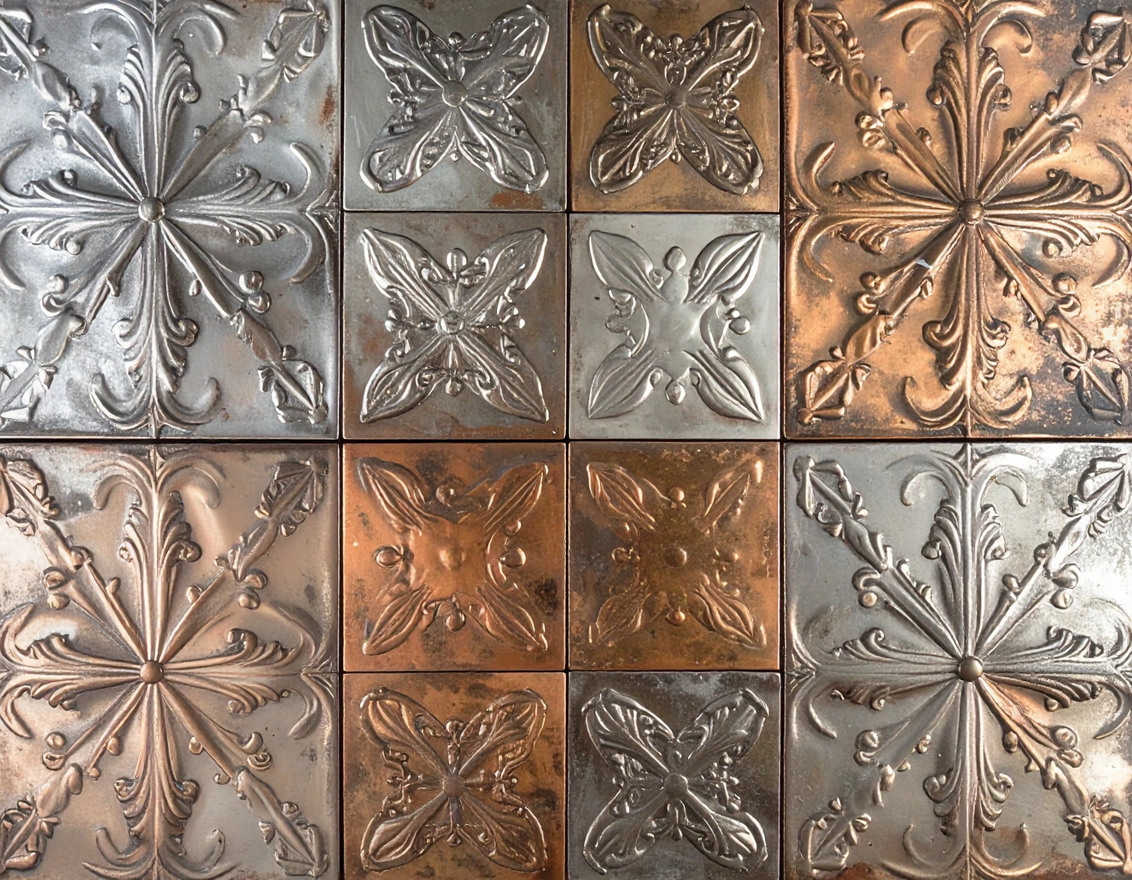Decorative metal tiles with embossed patterns in various colors.