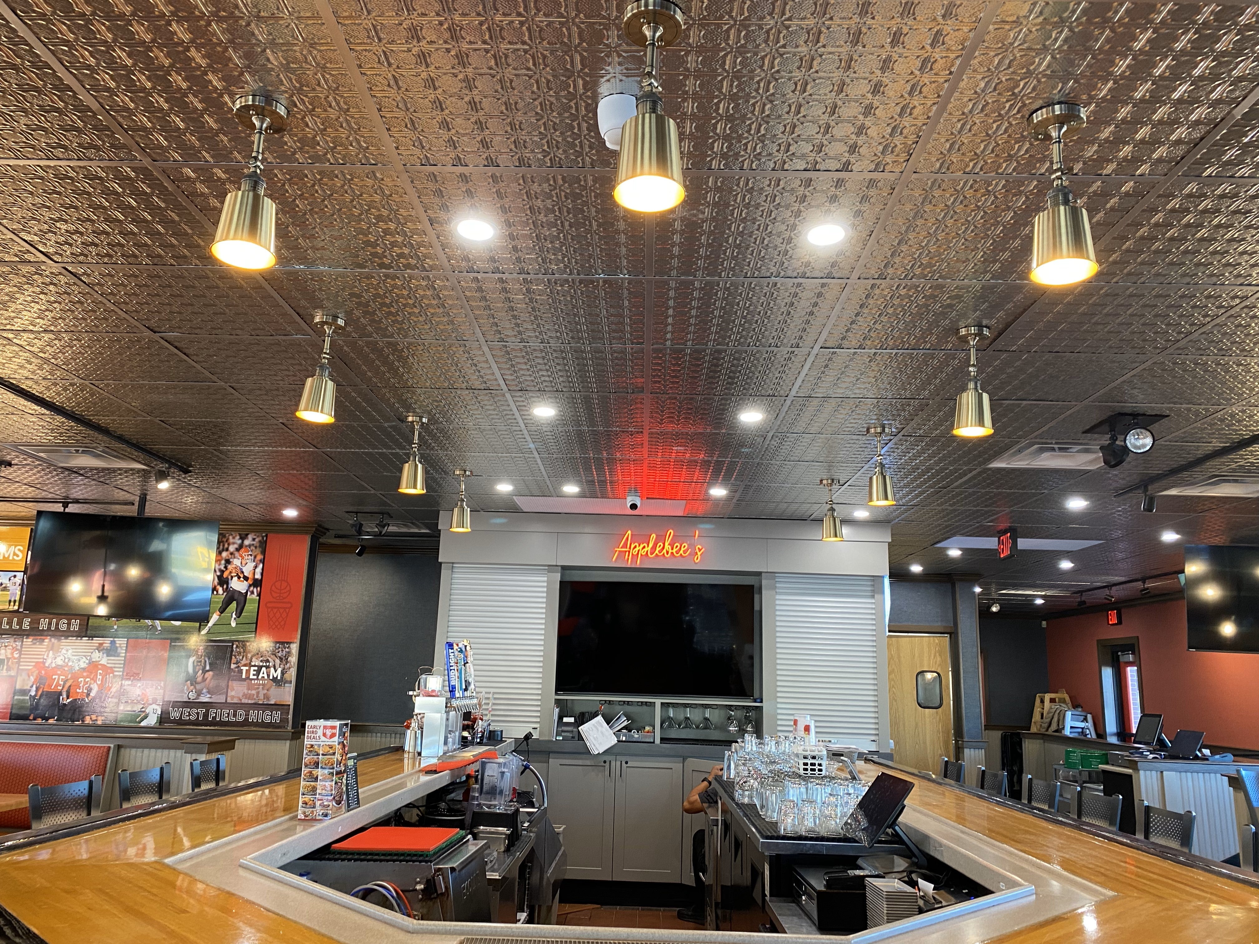 Bar area with television screens, drinks, and patrons in a casual setting.