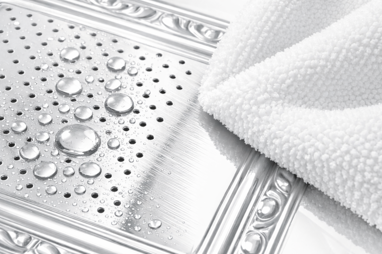 Metallic surface with water droplets and a white towel.