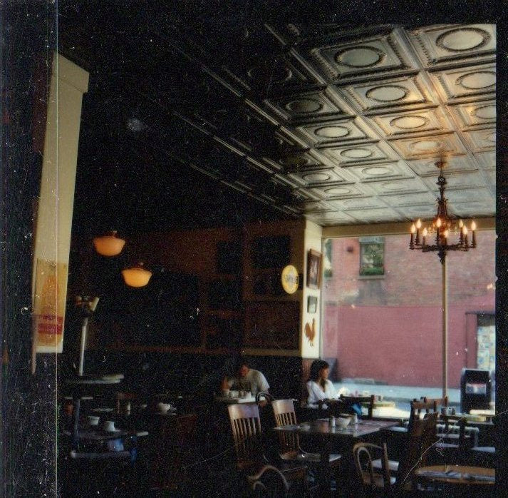 Interior of a restaurant with patrons and a decorative ceiling.