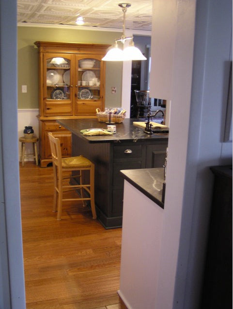 Kitchen with wooden cabinets, island, and bar stools.