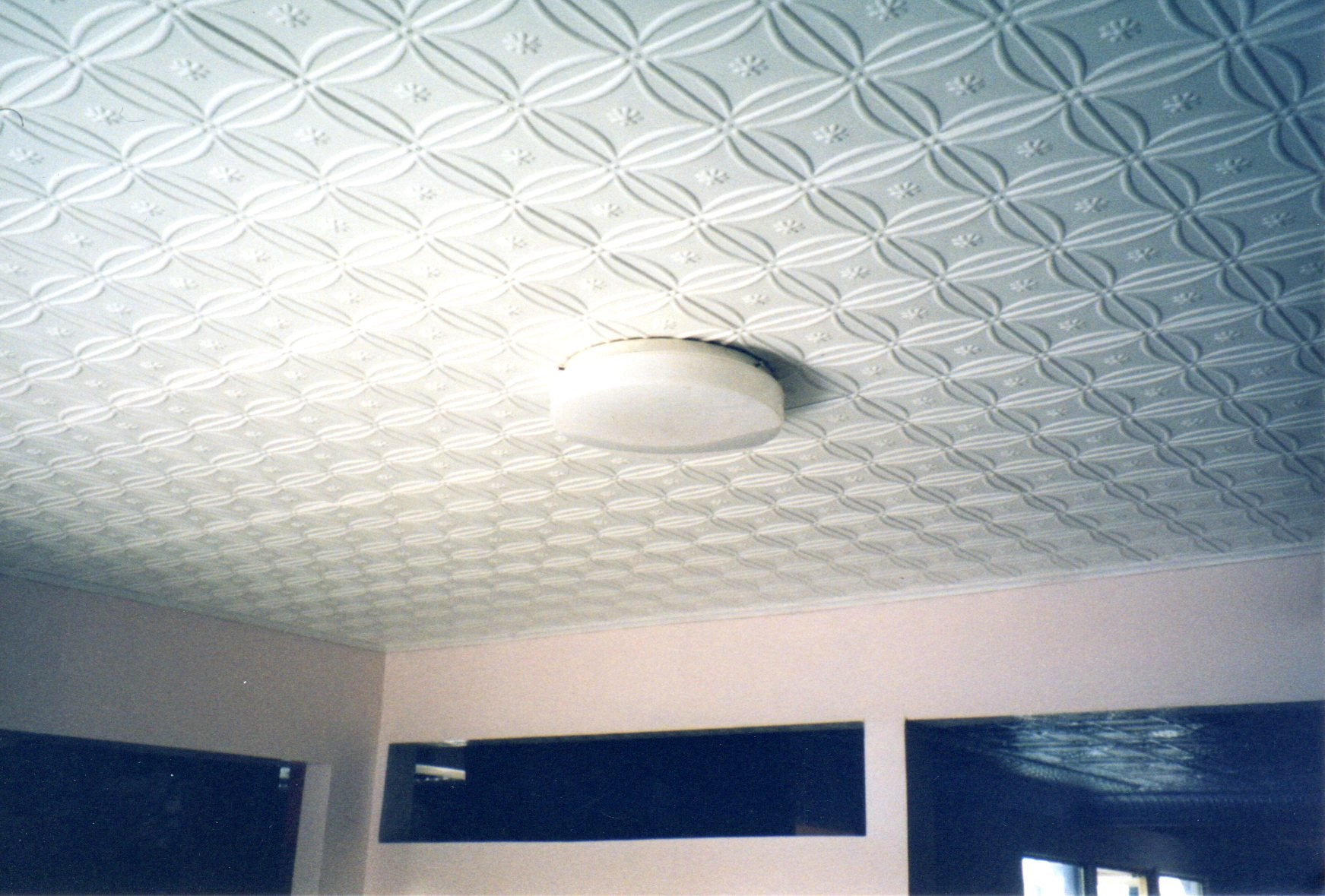 Ceiling with textured white pattern and a light fixture