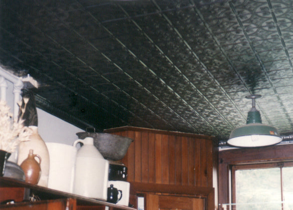 Vintage interior with patterned ceiling, wooden furniture, and decorative items.