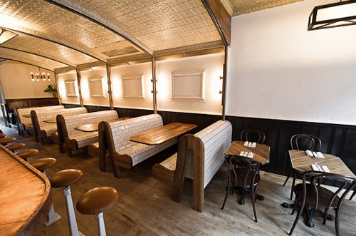 Dining area with wooden tables and benches in a restaurant setting.
