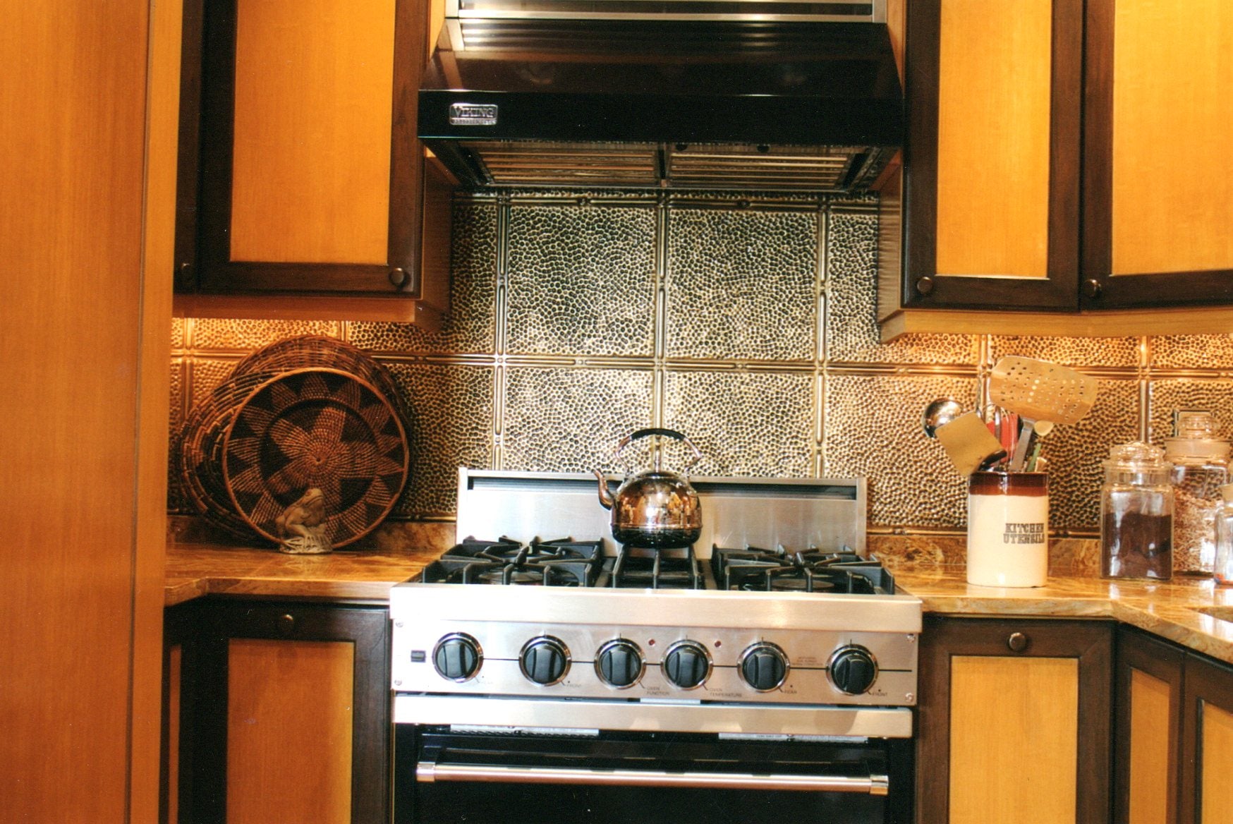 Kitchen with stove, decorative backsplash, and wooden cabinets