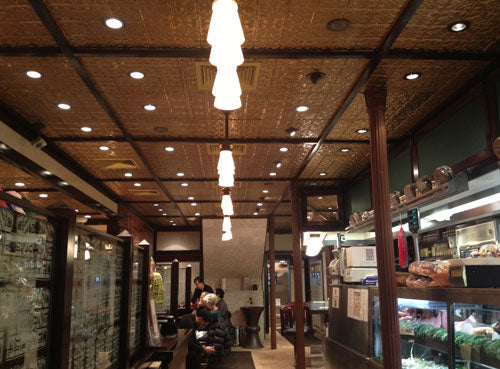 Interior of a restaurant with wooden ceiling and patrons seated.