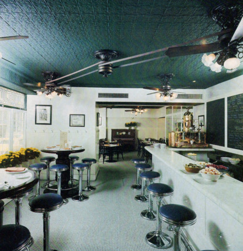 Diner interior with green ceiling, tables, and stools.