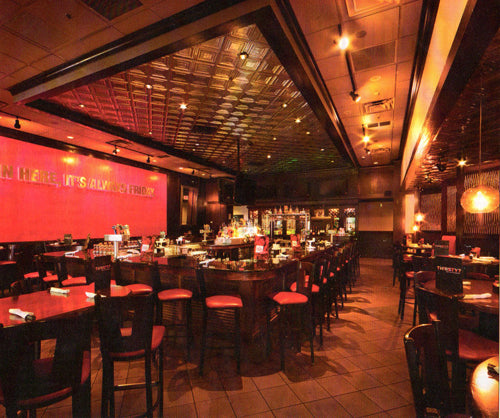 Bar interior with red walls, wooden bar, and stools.