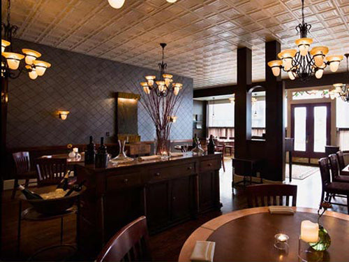 Dining room with ornate lighting fixtures, wooden tables, and chairs.