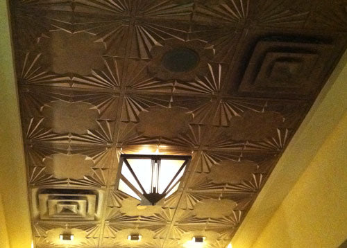 Decorative ceiling with geometric patterns and a light fixture.