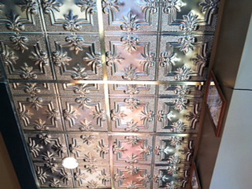Decorative ceiling with tin tiles in a room corner.
