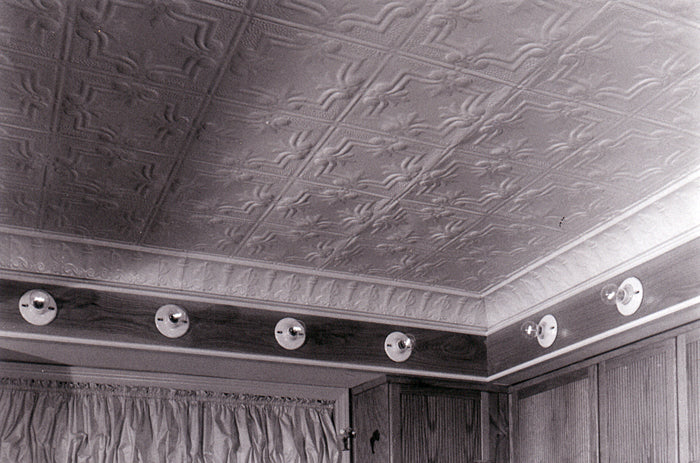 Textured ceiling with decorative border and lights in a room.