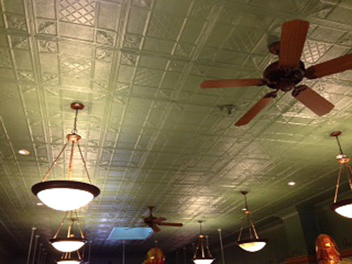 Ceiling with decorative tiles, a ceiling fan, and hanging lights.