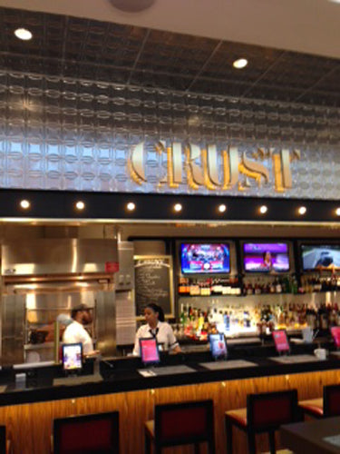 Restaurant interior with 'CRUST' sign above the counter