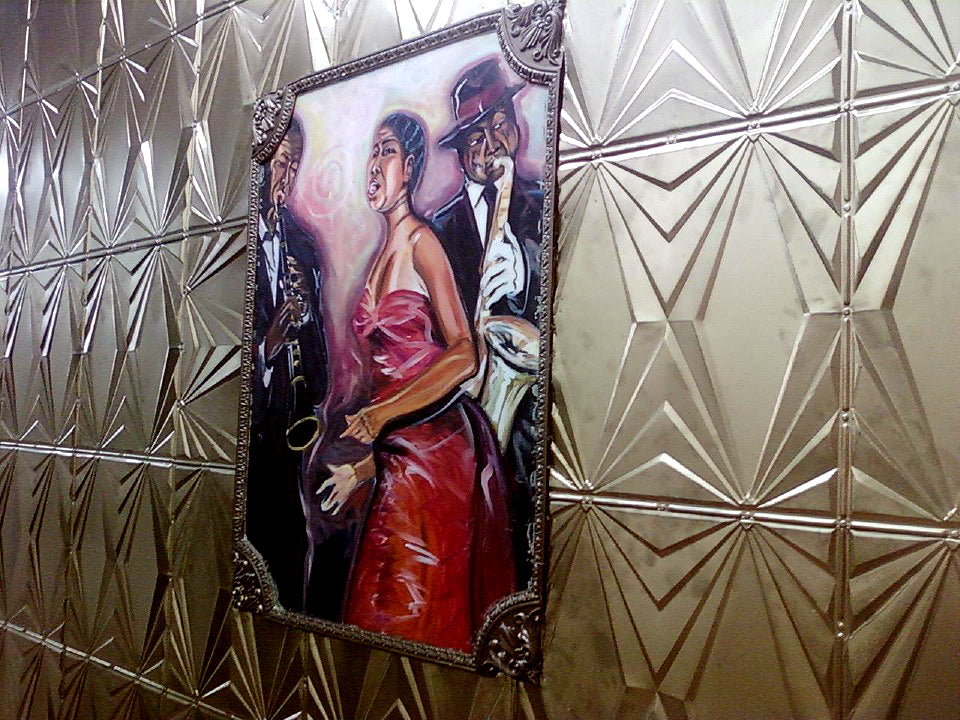 Framed artwork of a couple dancing on a metallic wall.
