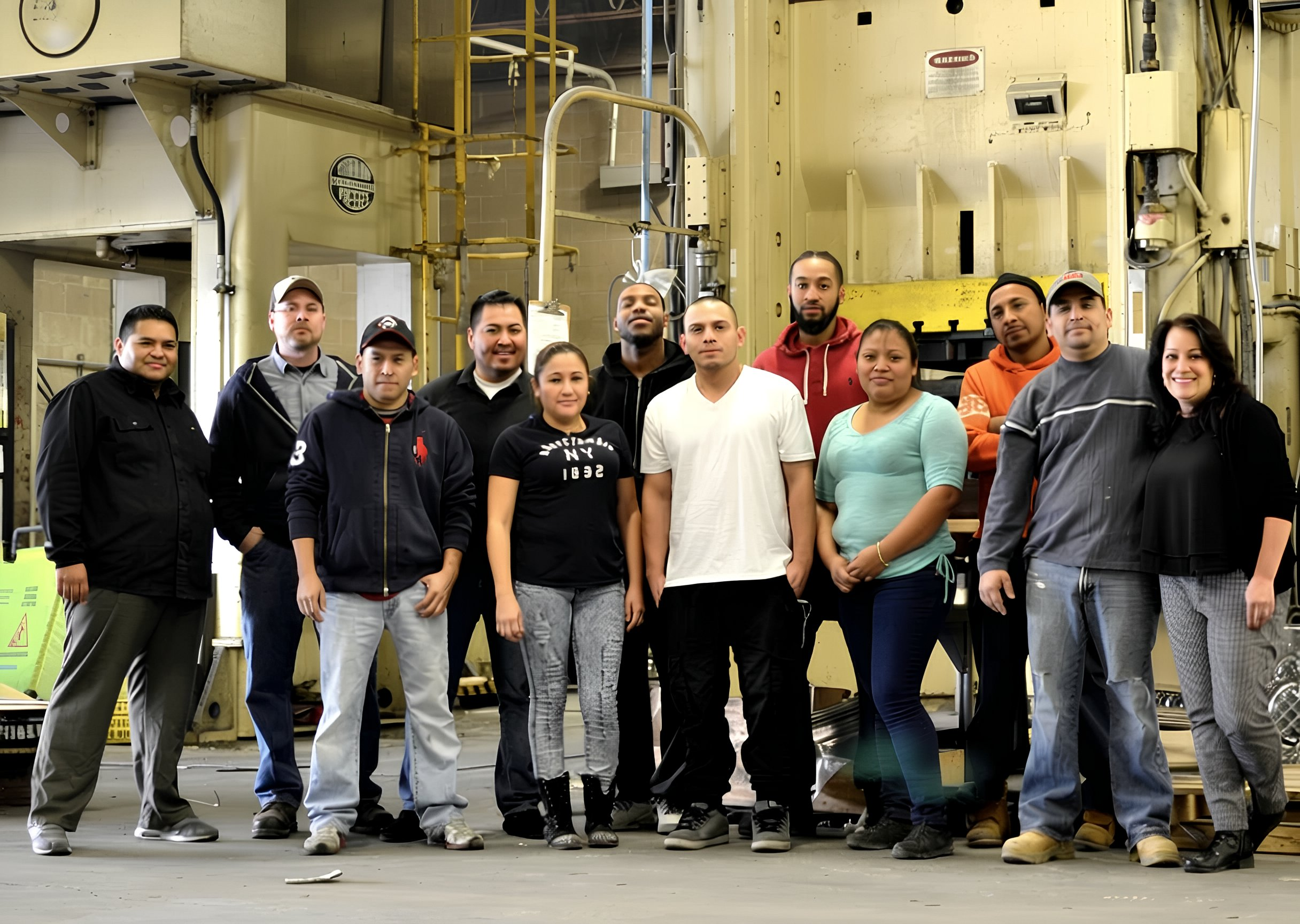 Group of people posing for a photo in an industrial setting