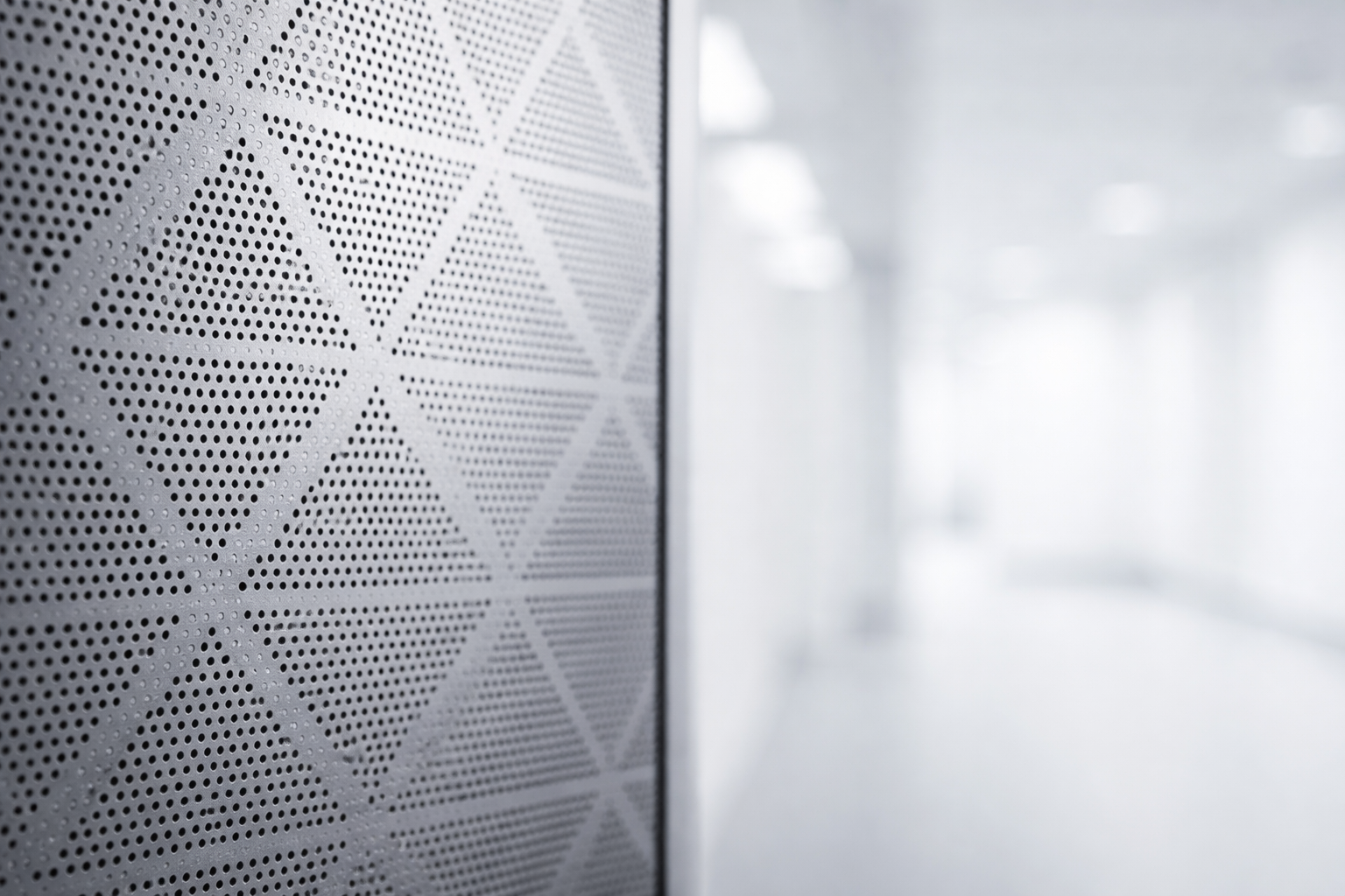 Perforated metal panel with geometric pattern.