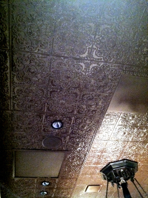 Decorative ceiling with patterned tiles and light fixture