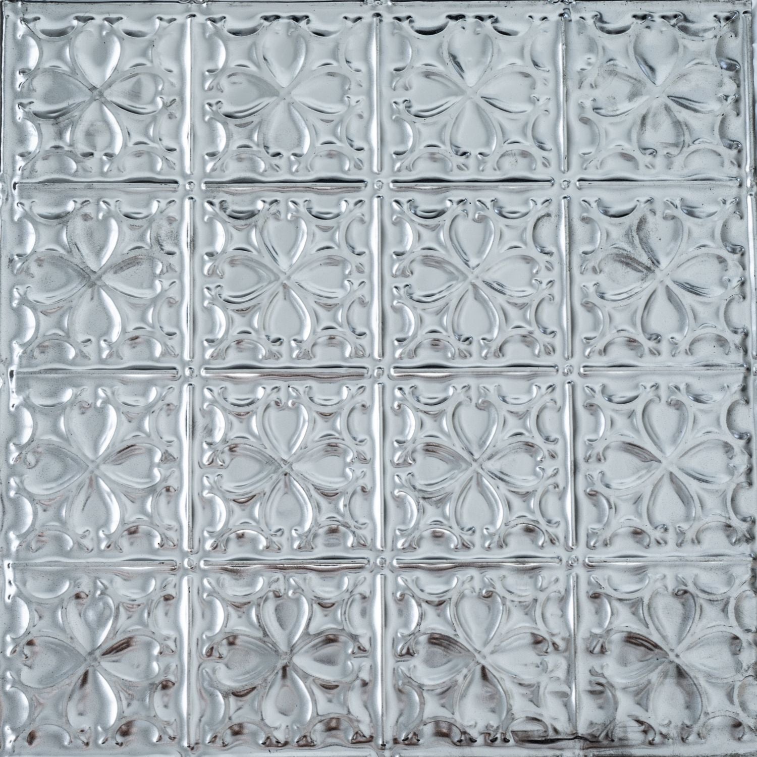 Decorative metallic tile with floral pattern.
