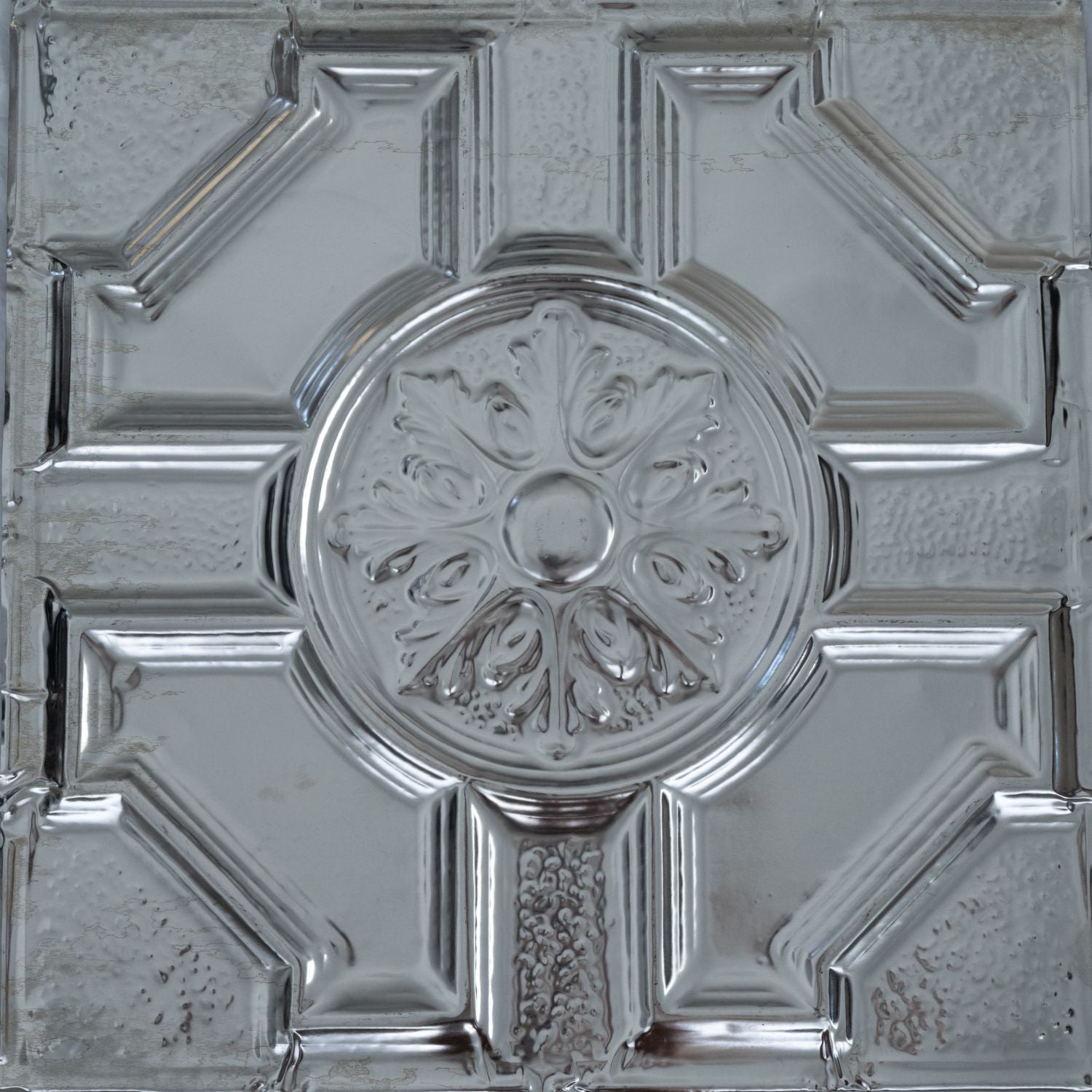 Decorative metallic ceiling tile with intricate design.