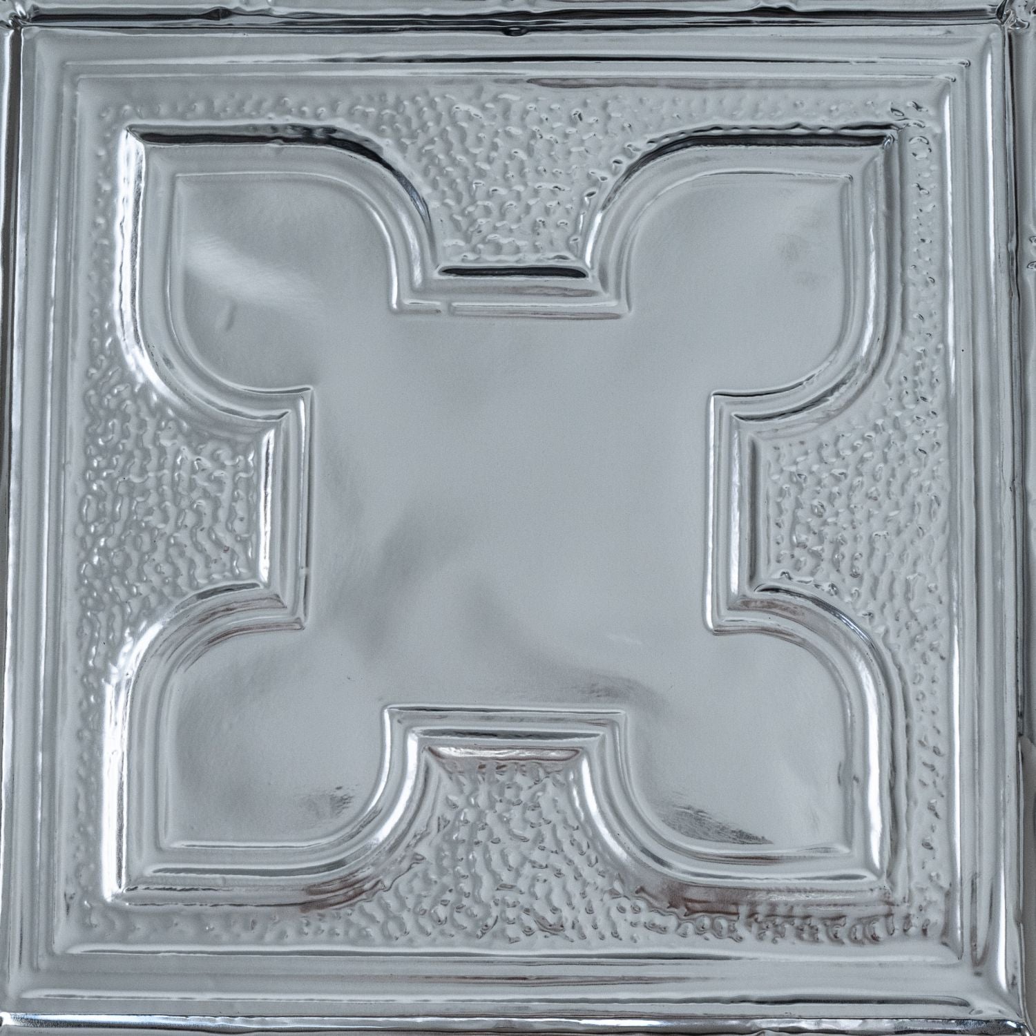 Decorative silver ceiling tile with intricate design.