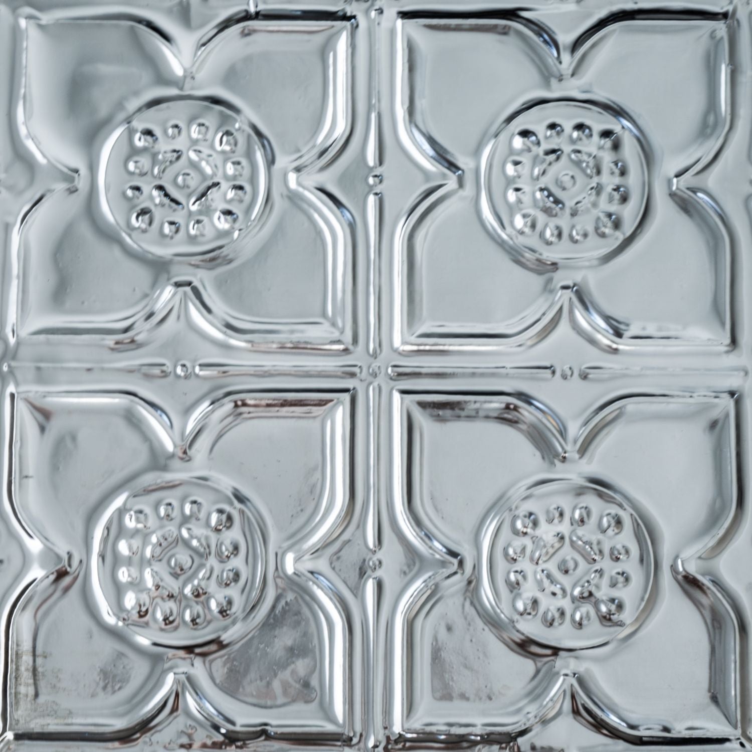Decorative metal ceiling tile with a geometric pattern.