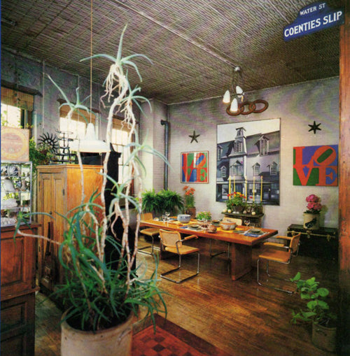 Interior of a store with wooden tables, chairs, and decorative plants.