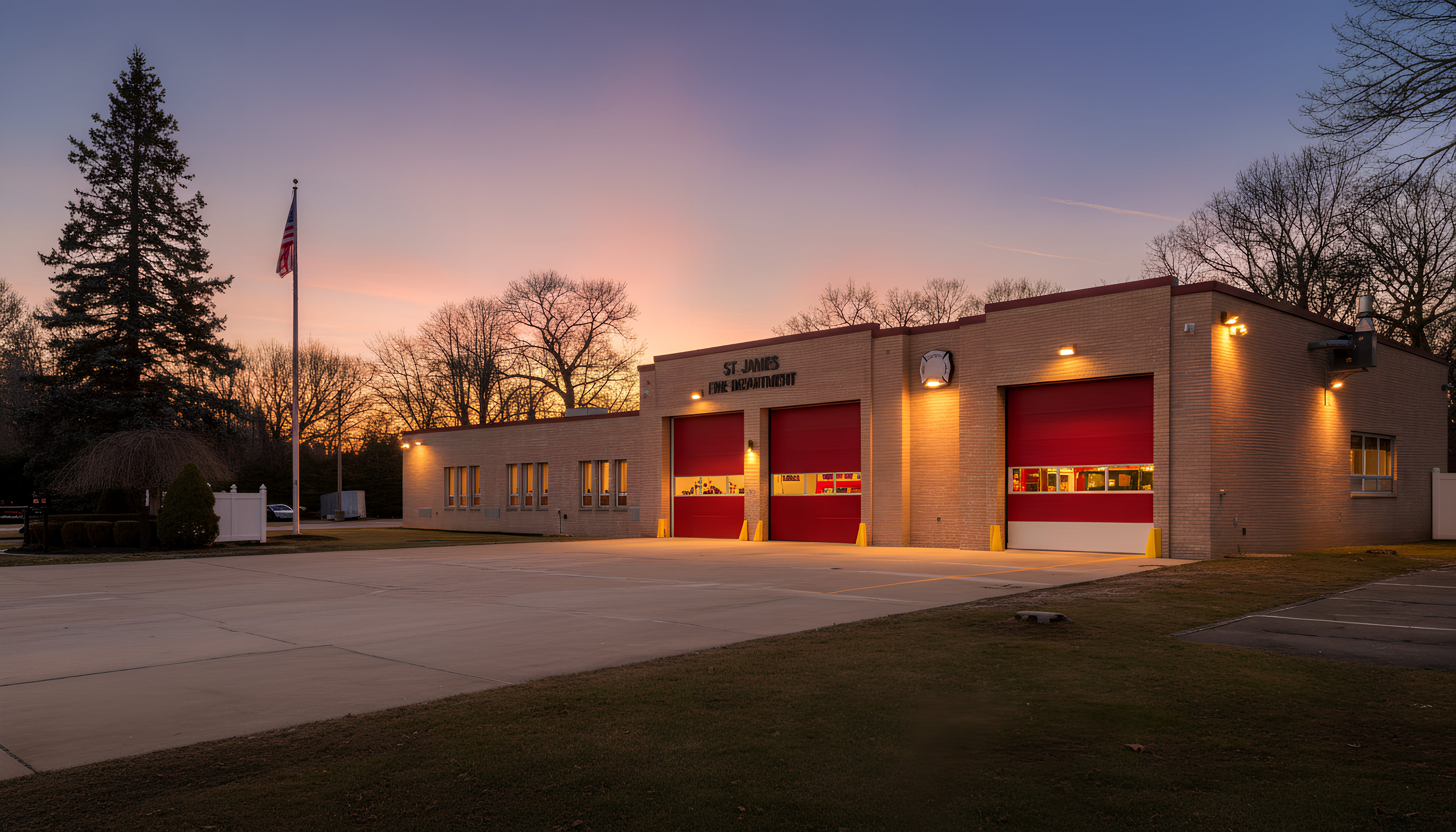 Fire station building with red doors at dusk.